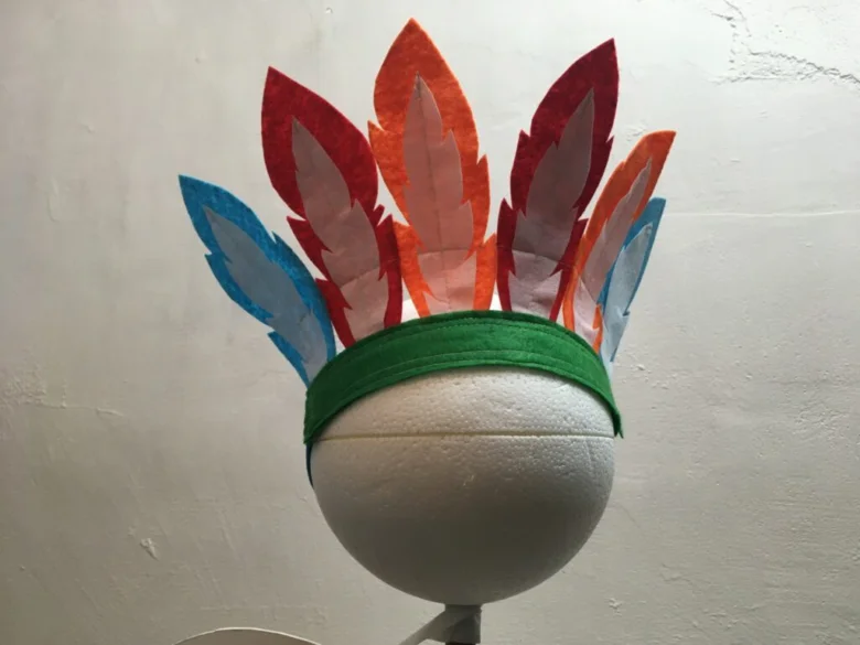 Hotový indianský čelenka s barevnými peříčky na hlavě.