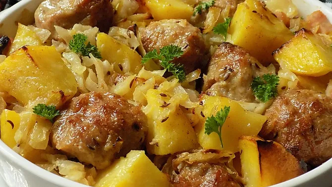 Zapečené hlávkové zelí s masem v bílé misce.