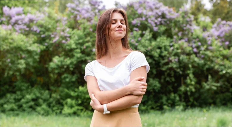 Žena v zahradě se zavřenýma očima při meditaci.