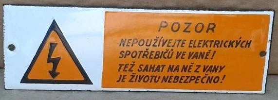 Varovná značka v koupelně o nebezpečí elektrických spotřebičů.