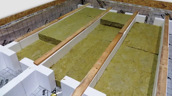 Izolace stropu na půdě s minerální vlnou mezi dřevěnými trámy