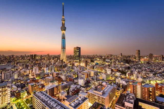 Tokyo Skytree ve večerním osvětlení nad městem.