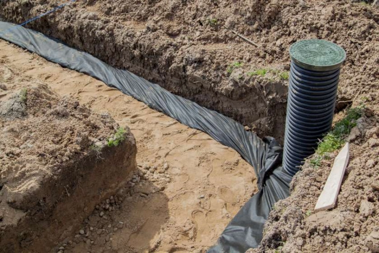 Instalace drenážní trubky do příkopu s geotextilií