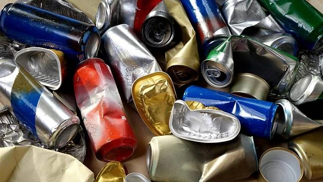 Stlačené plechovky na recyklaci, různých barev a velikostí