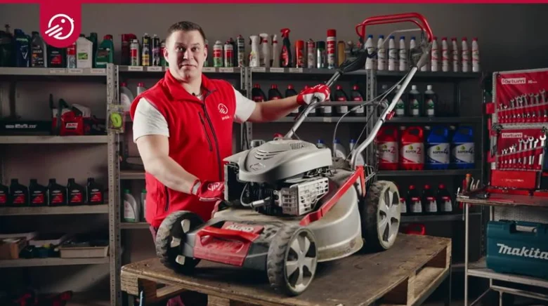 Mechanik s benzínovou sekačkou v dílně