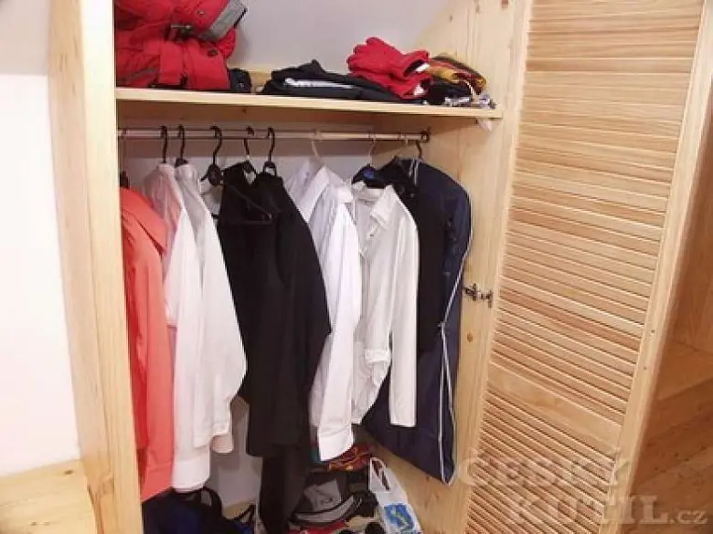Dřevěná skříň s oblečením a úložným prostorem