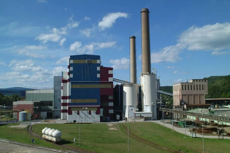 Tepelná elektrárna s vysokými komíny na pozadí modré oblohy.