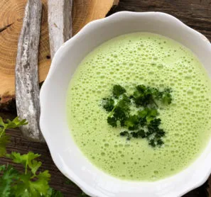 Jednoduchá zelená vegetariánská polévka v bílé misce.