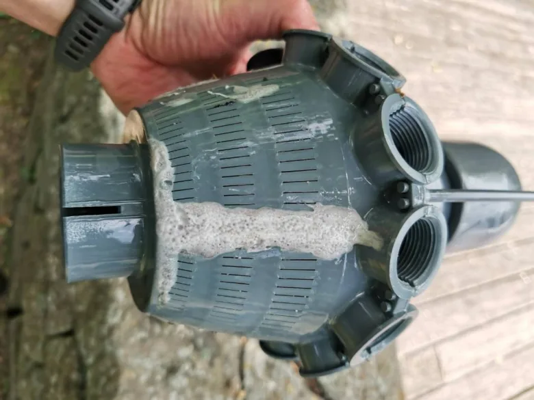 Znečištěný filtr bazénu s pískem po čištění