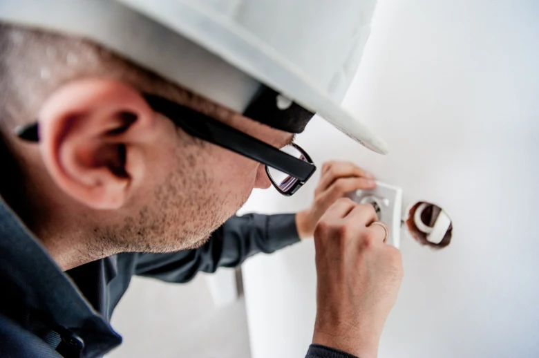 Elektrikář instaluje zásuvku v koupelně během rekonstrukce.