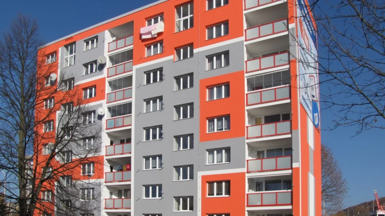 Moderní bytový dům s oranžovou fasádou.