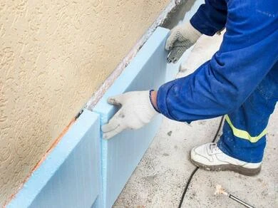 Montáž izolačních desek z polystyrénu na spodní část fasády.