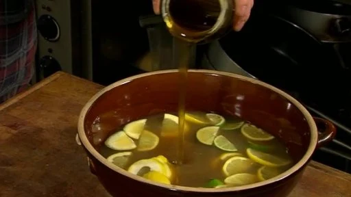 Lidé nalévají zázvorovou limonádu s citrony do misky.