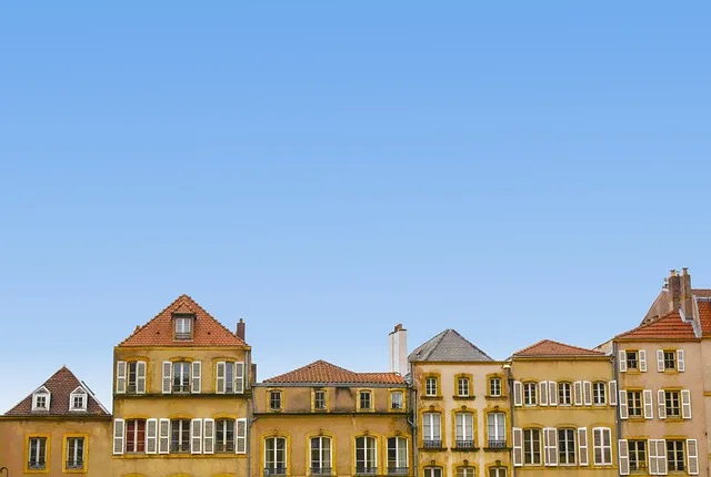 Řada starých domů pod modrou oblohou jako ilustrační foto pro článek o vlastnictví.
