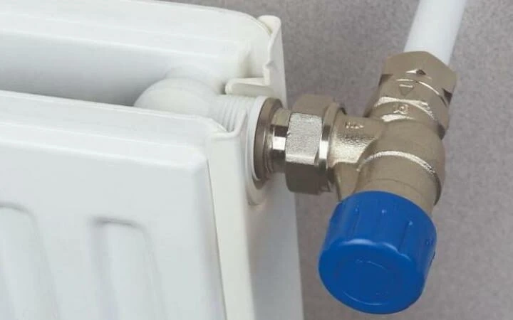Detail připojení radiátoru s modrým ventilovým kolečkem