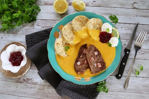 Hotová svíčková s houskovými knedlíky a brusinkovou omáčkou.