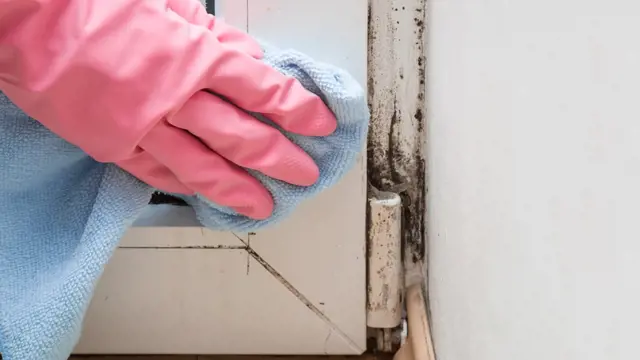 Čištění plastového okenního rámu rukavicí a utěrkou