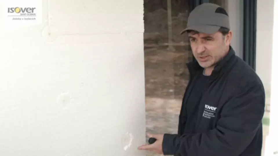 Muž ukazuje na lepené polystyrenové desky s bodovým spájkem.