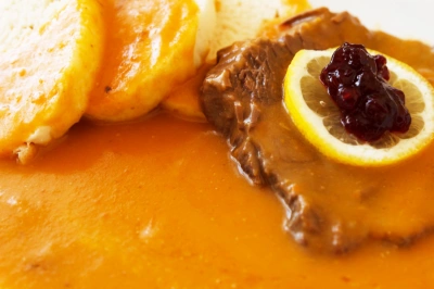Hot svíčková s brusinkami a citronem na zelném salátu.