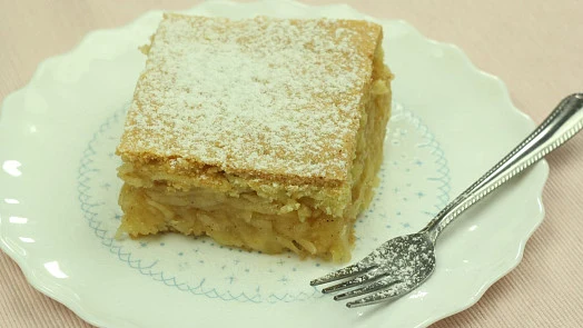 Kousek strouhaného jablečného koláče s pudinkem na talíři