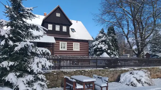 Malá chata v zimě s sněhem na stromech
