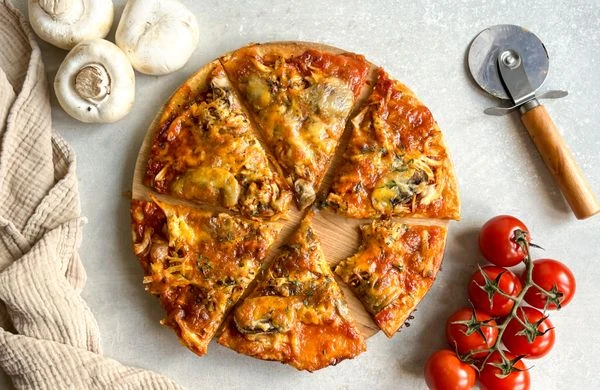 Pikantní pizzy s žampiony nakrájená na kousky.