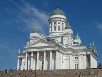Bílá katedrála v Helsinkách na modré obloze s lidmi.