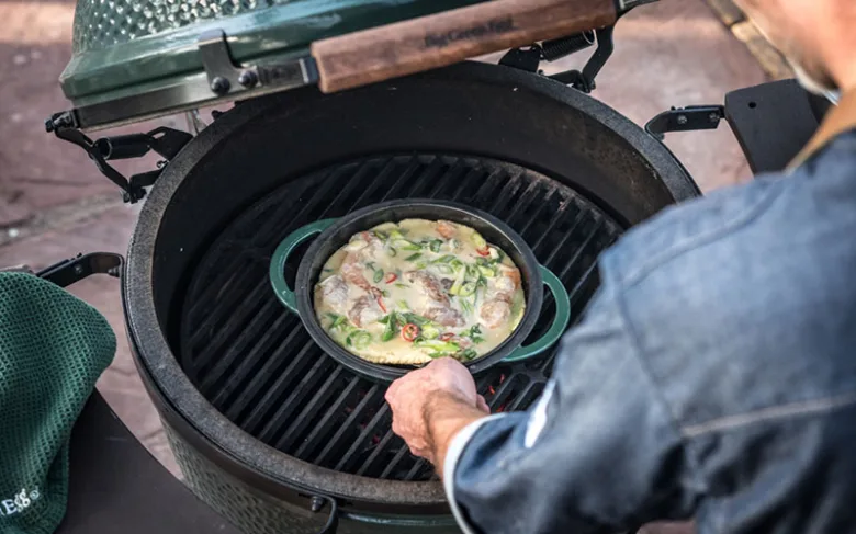 Příprava korejské palačinky na otevřeném uhlíkovém grilu.